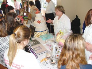 Oak Island's CrazyCakeChicks chat up brides at their booth during last year's Southern Cape Fear Coast Bridal Showcase. Courtesy photo