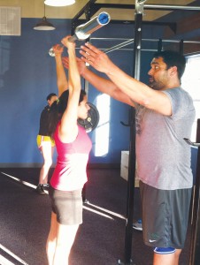 John Surigao of CrossFit Safe Haven assists a student. Photo by Kris Beasley
