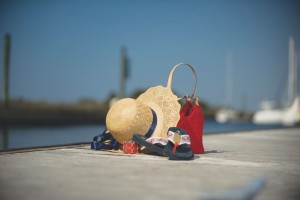 Straw Hat with navy ribbon, $10; red circle bracelet, $8; J Crew navy with red lobster flip-flops, $12; Ann Taylor red purse, $15; all from Klassy Konsignment (4105 Long Beach Rd., 910-457-0402).