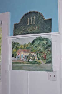 A painting by an unknown artist was left as a gift by a neighbor on the Rustins' back porch. It acts as an ode to the house beside the front entry. Photo by Bethany Turner