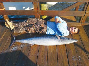 READER SUBMITTED: Tommy Scheetz of Southport lies beside a huge wahoo he caught this summer. Courtesy photo