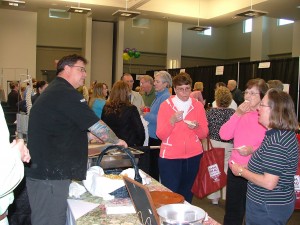 Chef Stephen Phipps of Mr. P's Bistro dishes out samples of seafood appetizers at a past Coastal Consumer Showcase. Photo courtesy of the Southport-Oak Island Area Chamber of Commerce.