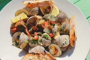 Local clams sautéed in a garlic herb broth with Tasso ham, diced tomatoes, and red onions and served with toast points. Photo by Bethany Turner