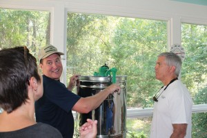 Dr. Reschly hand-cranks the extractor to remove all honey from the slats. Photo by Kris Beasley