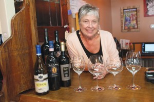 Candace Hobbs, owner of The Grape & Ale, displays various crystal wine glasses crafted by Riedel, which enhance the flavors of each varietal as well as the experience of enjoying wine. Photo by Kris Beasley