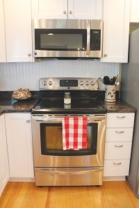 Stainless steel appliances, custom white cabinetry, and granite countertops offer modern appeal in this historic-district home. Photo by Bethany Turner